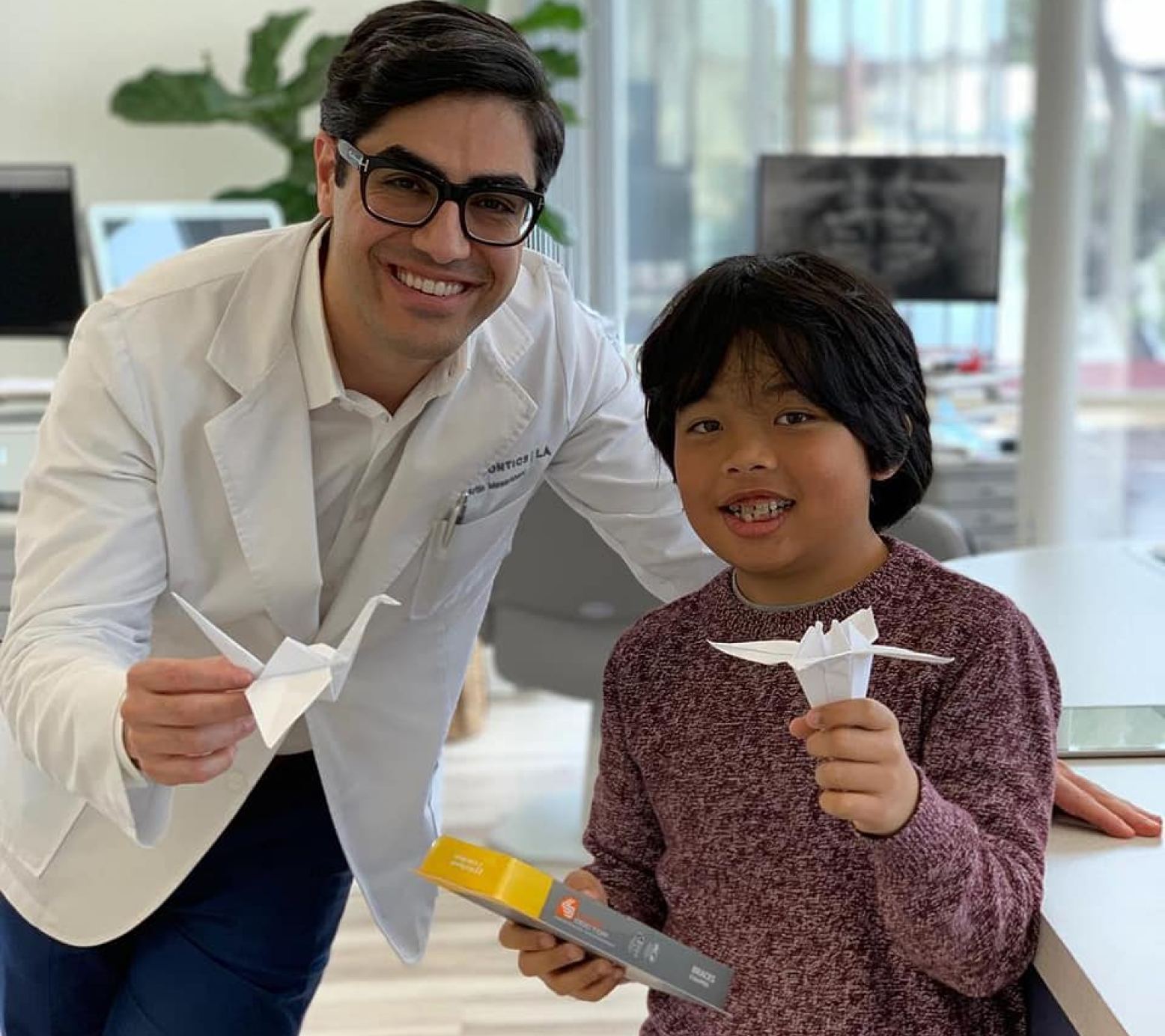 Dr. Artin and a patient holding up origami